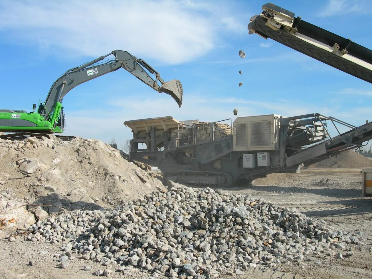 Excavator feeding a mobile crusher — primary crushing